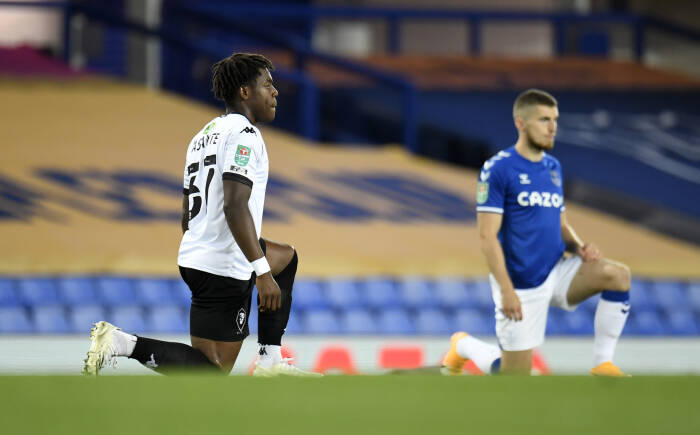 Brandon Thomas-Asante dari Salford City berlutut untuk mendukung kampanye Black Lives Matter sebelum pertandingan (REUTERS/PETER POWELL) Brandon Thomas-Asante dari Salford City berlutut untuk mendukung kampanye Black Lives Matter sebelum pertandingan