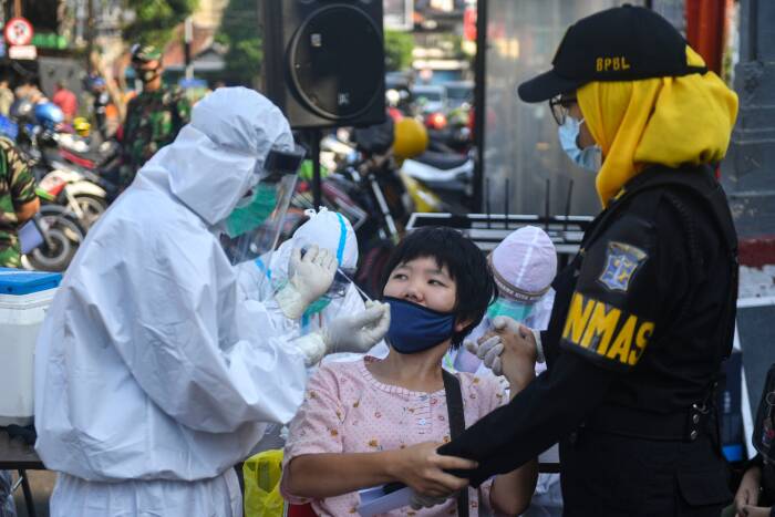 Seorang tenaga kesehatan yang mengenakan alat pelindung diri lengkap dibantu petugas Linmas melakukan tes usap (swab test) COVID-19 pada anak berkebutuhan khusus (ABK). ANTARA FOTO/M Risyal Hidayat Seorang tenaga kesehatan yang mengenakan alat pelindung diri lengkap dibantu petugas Linmas melakukan tes usap (swab test) COVID-19 pada anak berkebutuhan khusus (ABK)