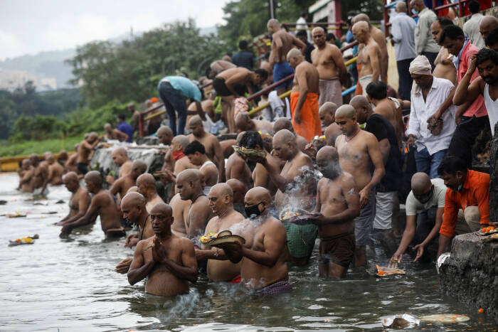 REUTERS/Francis Mascarenhas Para penyembah berdoa saat mereka berenang di danau untuk menghormati jiwa leluhur mereka yang telah meninggal pada hari keberuntungan di Mahalaya