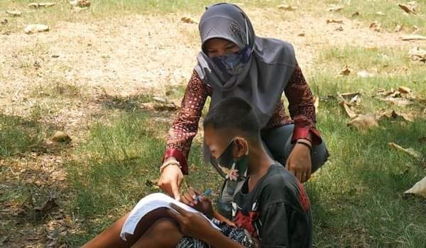Noor Rahmat mengerjakan ujian sambil menggembala kambing (Facebook/Yuni Rusmini) Noor Rahmat mengerjakan ujian sambil menggembala kambing