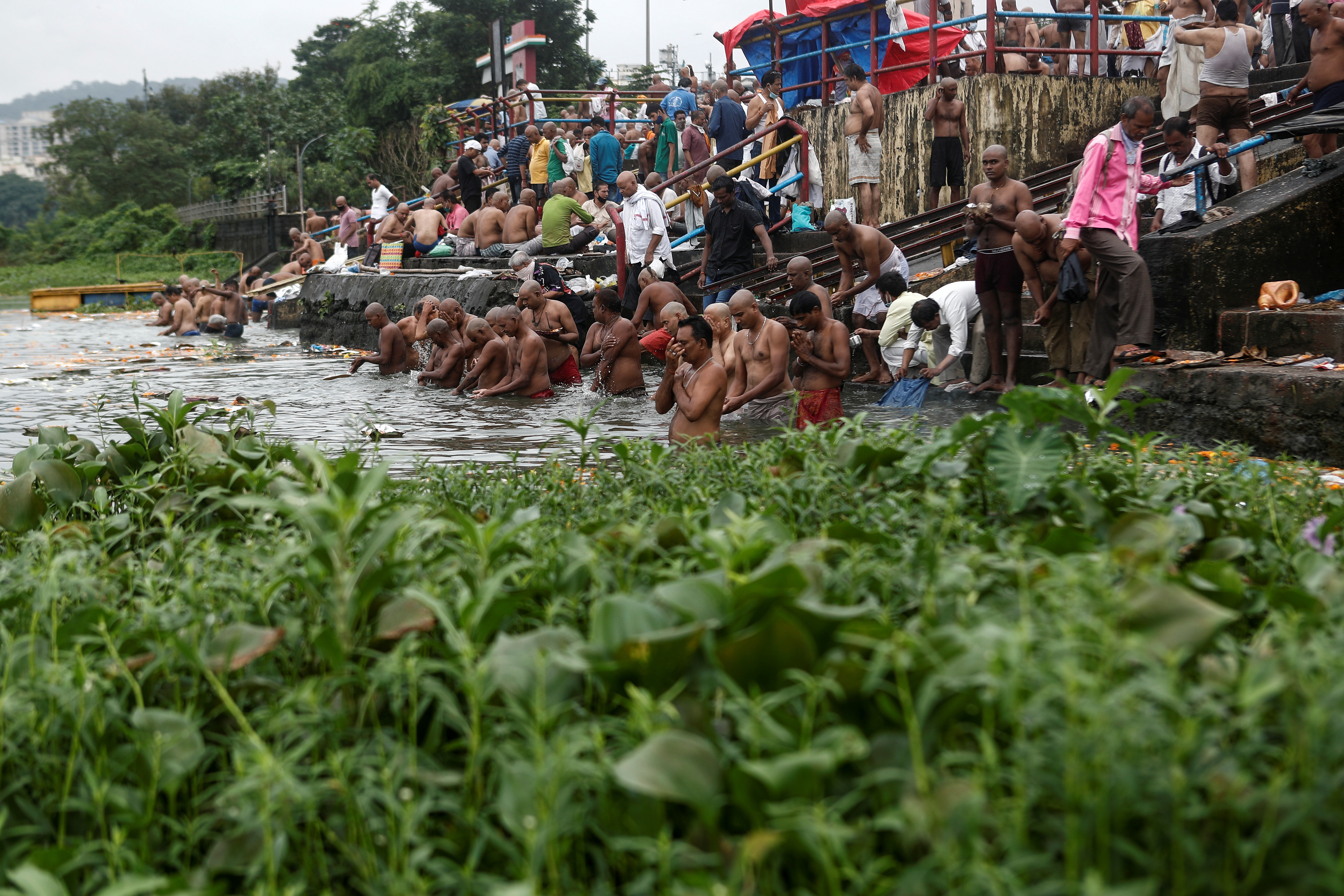 REUTERS/Francis Mascarenhas Para penyembah berdoa saat mereka berenang di danau untuk menghormati jiwa leluhur mereka yang telah meninggal pada hari keberuntungan di Mahalaya