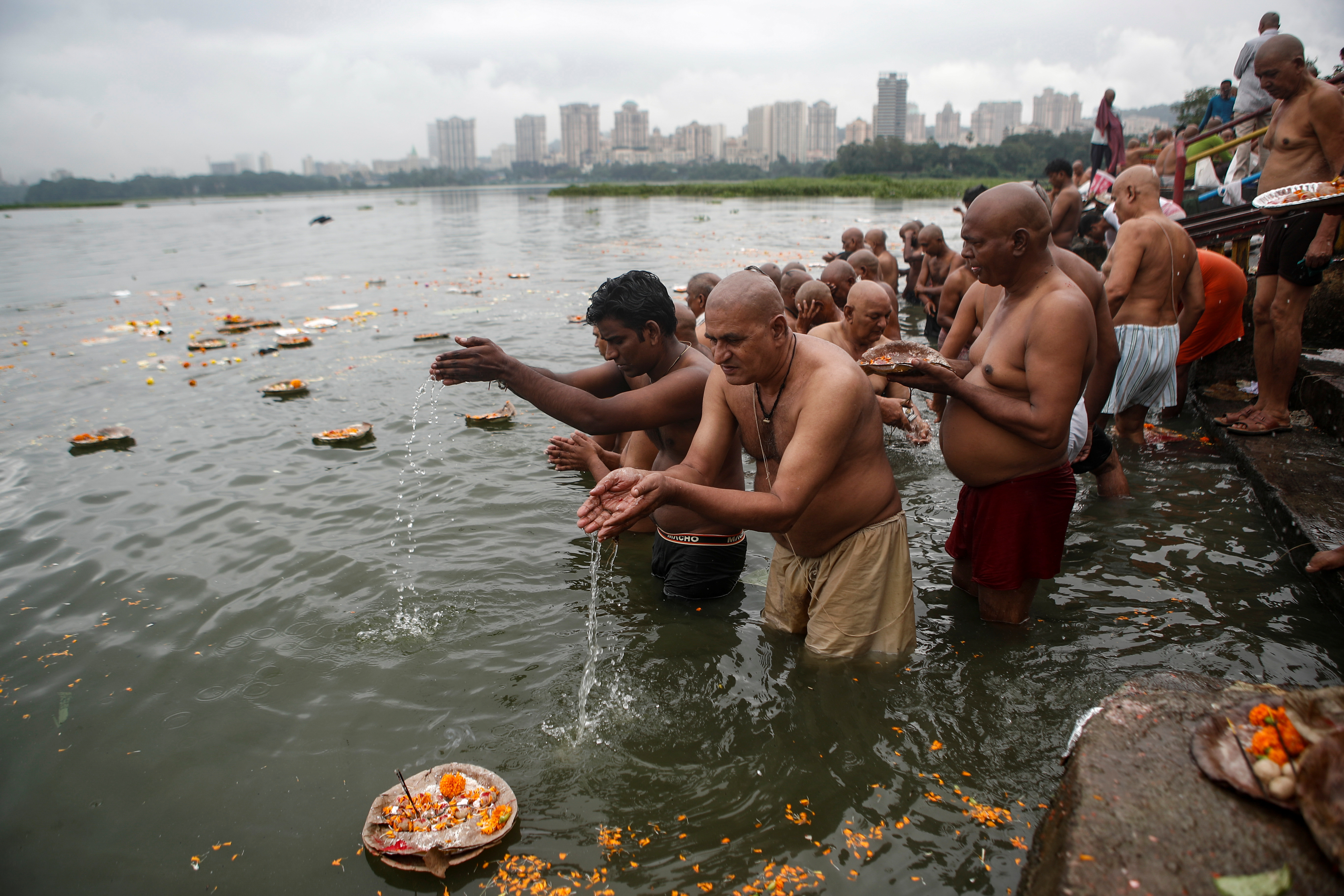 REUTERS/Francis Mascarenhas Para penyembah berdoa saat mereka berenang di danau untuk menghormati jiwa leluhur mereka yang telah meninggal pada hari keberuntungan di Mahalaya