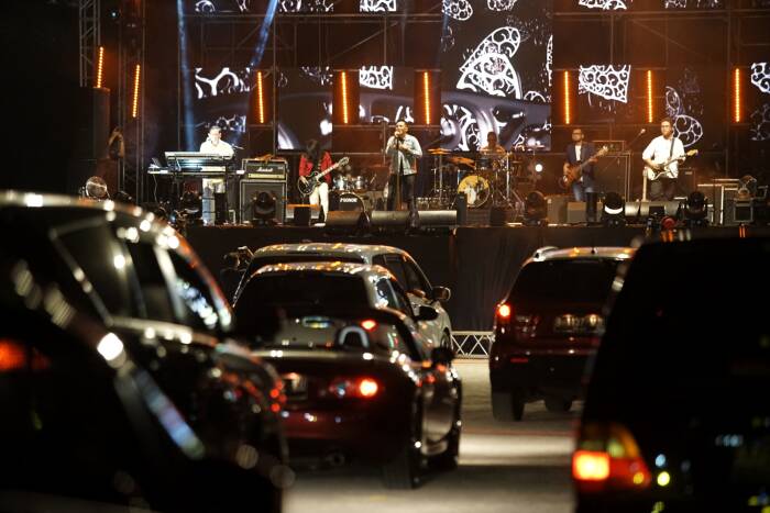 Penonton menyaksikan penampilan band Jikustik dari dalam mobil (ANTARA FOTO/Andreas Fitri Atmoko) Penonton menyaksikan penampilan band Jikustik dari dalam mobil