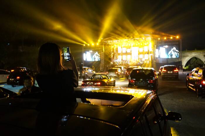 ANTARA FOTO/Andreas Fitri Atmoko Penonton menyaksikan penampilan band Jikustik dari dalam mobil saat konser musik drive-in di Sleman City Hall, D.I Yogyakarta, Minggu (20/9/2020).