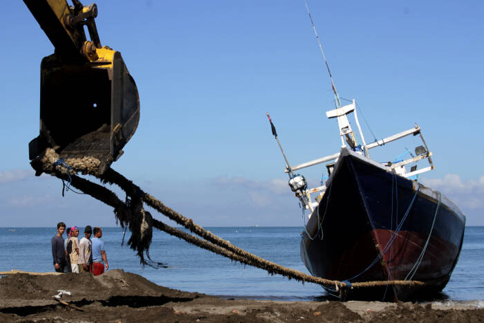 Pekerja melihat kapal nelayan yang ditarik ke atas daratan menggunakan alat berat sebelum diperbaiki di Pantai Batu-Batu (ANTARA FOTO/Arnas Padda) Pekerja melihat kapal nelayan yang ditarik ke atas daratan menggunakan alat berat sebelum diperbaiki di Pantai Batu-Batu