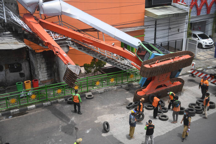 Petugas mengevakuasi ekskavator yang terguling menimpa tangga jembatan penyeberangan orang (JPO) di Kampung Melayu, Jakarta, Selasa (22/9/2020). (photo/ANTARA FOTO/Akbar Nugroho Gumay/) ekskavator terguling
