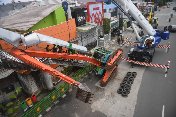 Petugas mengevakuasi ekskavator yang terguling menimpa tangga jembatan penyeberangan orang (JPO) di Kampung Melayu, Jakarta, Selasa (22/9/2020). (photo/ANTARA FOTO/Akbar Nugroho Gumay/) ekskavator terguling