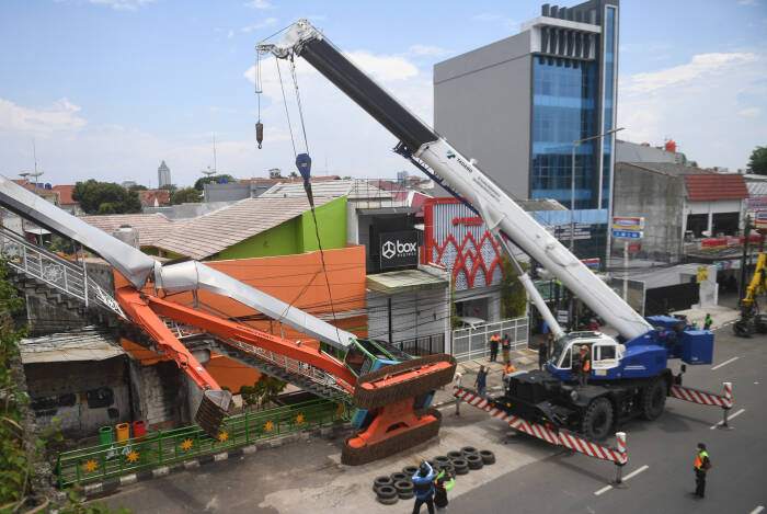 Petugas mengevakuasi ekskavator yang terguling menimpa tangga jembatan penyeberangan orang (JPO) di Kampung Melayu, Jakarta, Selasa (22/9/2020). (photo/ANTARA FOTO/Akbar Nugroho Gumay/) operator kelelelahan, ekskavator terguling