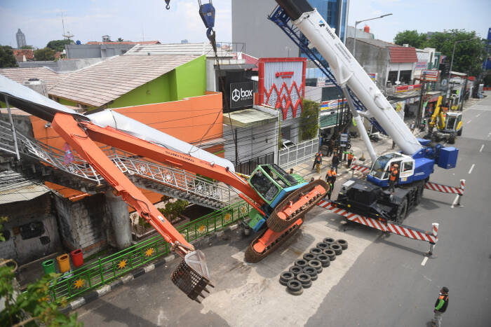 Petugas mengevakuasi ekskavator yang terguling menimpa tangga jembatan penyeberangan orang (JPO) di Kampung Melayu, Jakarta, Selasa (22/9/2020). (photo/ANTARA FOTO/Akbar Nugroho Gumay/) terguling