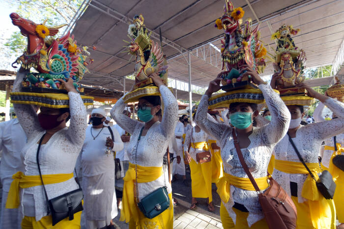 ANTARA FOTO/Nyoman Hendra Wibowo Umat Hindu menggunakan masker saat membawa benda-benda sakral dalam ritual menjelang Hari Raya Kuningan di Pura Sakenan, Denpasar, Bali, Jumat (25/9/2020).