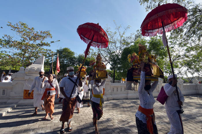 ANTARA FOTO/Nyoman Hendra Wibowo Umat Hindu menggunakan masker saat membawa benda-benda sakral dalam ritual menjelang Hari Raya Kuningan di Pura Sakenan, Denpasar, Bali, Jumat (25/9/2020)