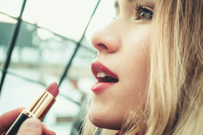 Ilustrasi wanita memakai lipstik. (Unsplash/@yirage) lipstik untuk hadiah wanita yang suka jalan-jalan