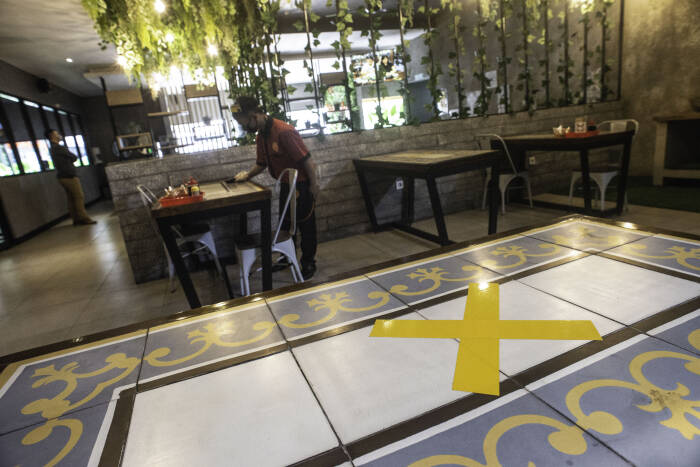 Pramusaji membersihkan meja makan di restoran Bebek Kaleyo, Kemanggisan, Jakarta, Senin (12/10/2020). ANTARA FOTO/Aprillio Akbar Pramusaji membersihkan meja makan di restoran Bebek Kaleyo, Kemanggisan, Jakarta, Senin (12/10/2020).