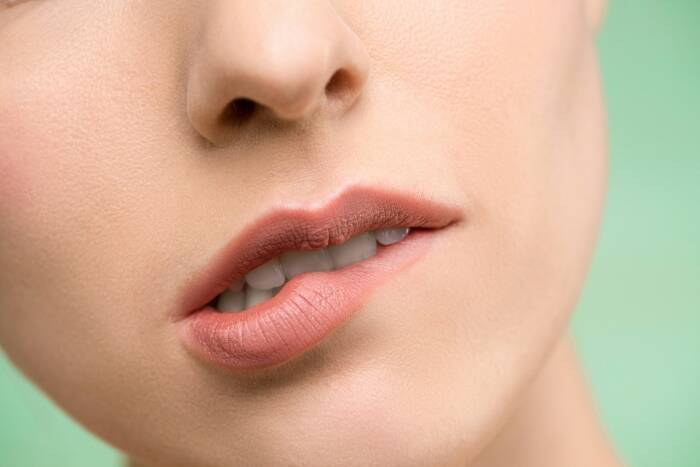 Ilustrasi menggigit bibir (helpyourskin.co.uk) penyebab bibir pecah pecah dan bibir kering