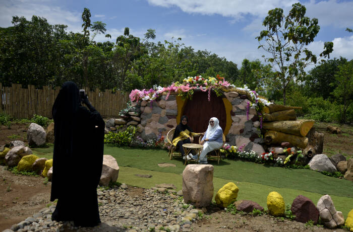 ANTARA FOTO/Abriawan Abhe Wisatawan berfoto dengan latar suasana rumah hobbit di obyek wisata Bollangi