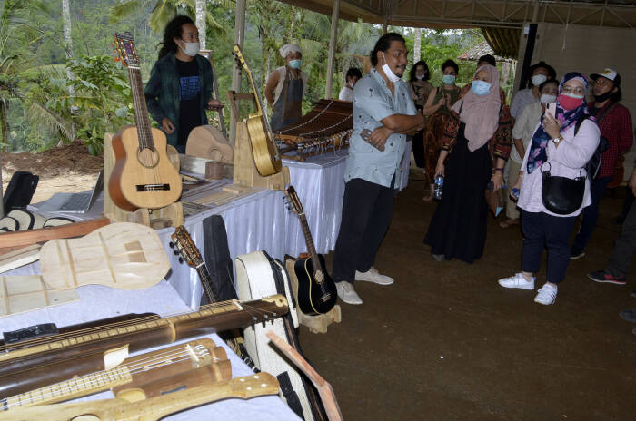 Perajin menjelaskan proses produksi alat musik tradisional buatannya kepada pengunjung (ANTARA FOTO/Fikri Yusuf) Perajin menjelaskan proses produksi alat musik tradisional buatannya kepada pengunjung
