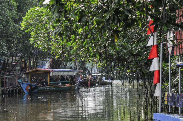 ANTARA FOTO/ Fakhri Hermansyah Sejumlah pengunjung menaiki peruhi berwisata di Hutan Mangrove Sungai Jingkem