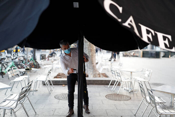 Seorang pekerja yang mengenakan masker pelindung menyiapkan bagian tempat duduk luar ruangan di bar Zurich di alun-alun Catalunya (REUTERS/Nacho Doce) Seorang pekerja yang mengenakan masker pelindung menyiapkan bagian tempat duduk luar ruangan di bar Zurich di alun-alun Catalunya