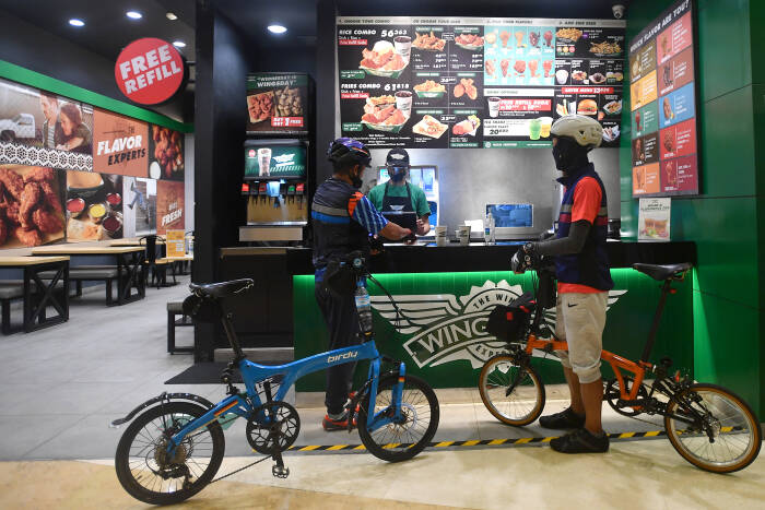 ANTARA FOTO/Sigid Kurniawan Pesepeda membeli makanan sambil membawa sepedanya di Mal Kuningan City, Jakarta Selatan, Sabtu (28/11/2020).