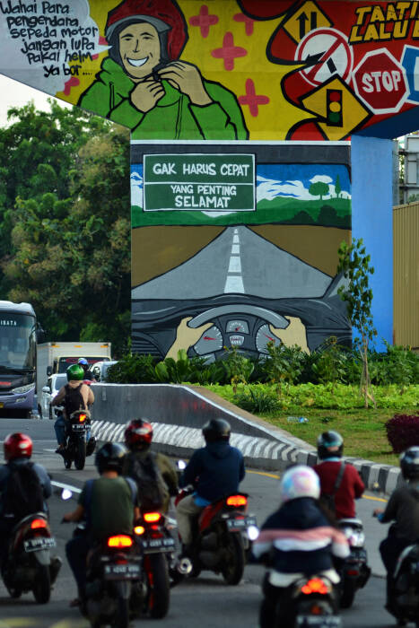 ANTARA FOTO/Suwandy Sejumlah kendaraan melintasi mural bertema taat berlalu lintas