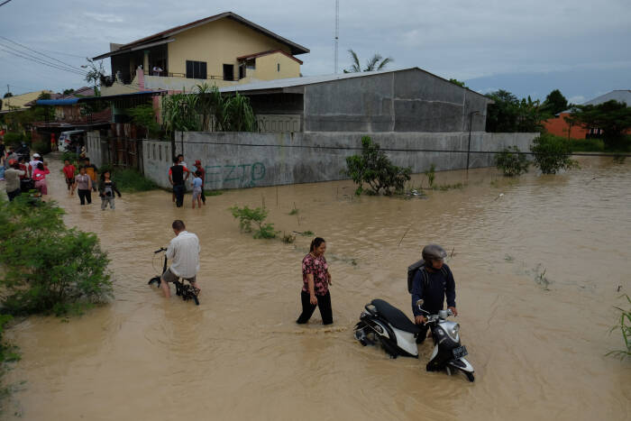 ANTARA FOTO/Irsan Mulyadi Warga melintasi banjir yang merendam pemukiman penduduk di Kecamatan Sunggal