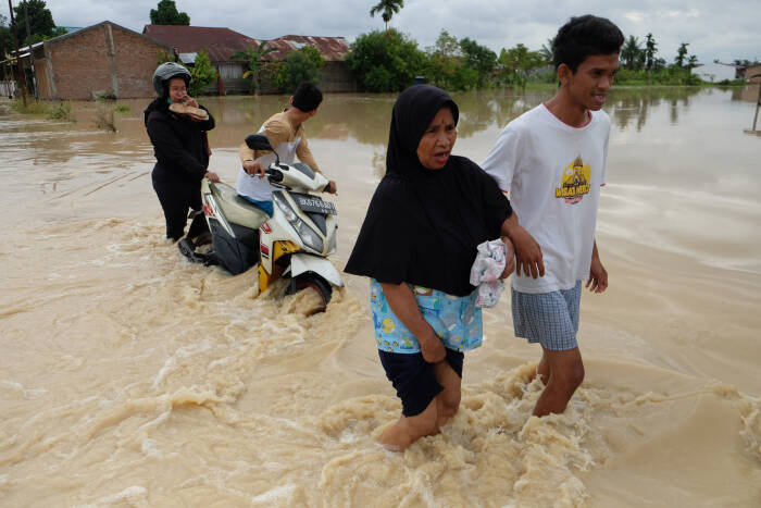 ANTARA FOTO/Irsan Mulyadi Warga melintasi banjir yang merendam pemukiman penduduk di Kecamatan Sunggal