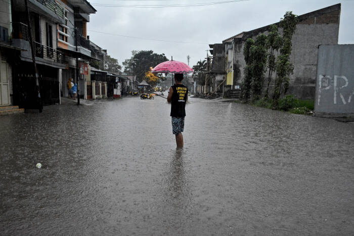 Warga melintasi genangan air di kawasan Tarogong Kidul (ANTARA FOTO/Candra Yanuarsyah) Warga melintasi genangan air di kawasan Tarogong Kidul