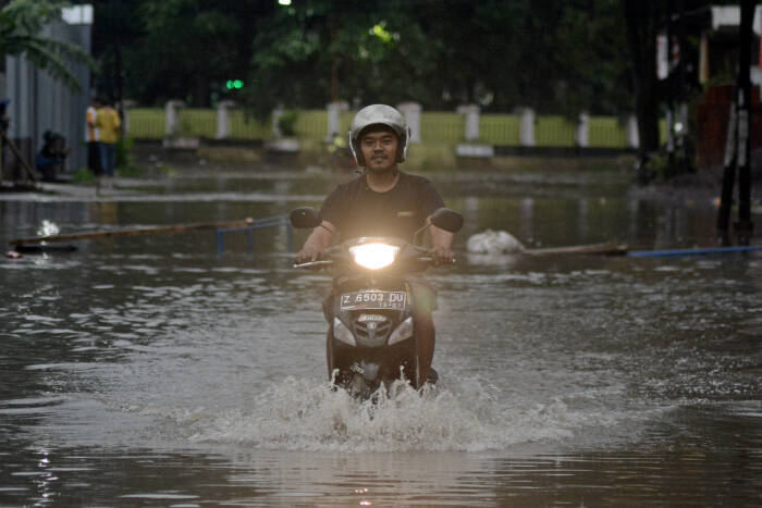 Pengendara motor melintasi genangan air (ANTARA FOTO/Candra Yanuarsyah) Pengendara motor melintasi genangan air (ANTARA FOTO/Candra Yanuarsyah)
