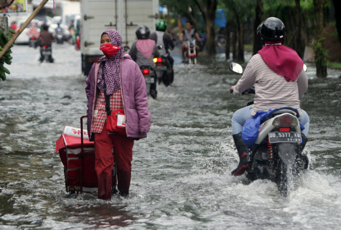 ANTARA FOTO/Arnas Padda Warga menerobos banjir di Makassar
