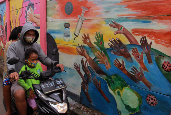 Pengendara melintas disamping mural yang bertemakan kampanye melawan COVID-19 (ANTARA FOTO/Muhammad Iqbal) Pengendara melintas disamping mural yang bertemakan kampanye melawan COVID-19
