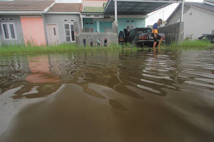 ANTARA FOTO/Dedhez Anggara Warga menerobos genangan banjir di perumahan desa Sindang