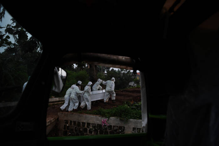ANTARA FOTO/Wahyu Putro A Petugas yang mengenakan APD bersiap membawa peti berisi jenazah dengan protokol COVID-19 di TPU Srengseng Sawah