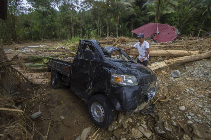 Warga melihat kondisi sebuah mobil yang rusak akibat banjir bandang di Desa Datar Ajab (ANTARA FOTO/Bayu Pratama S) Warga melihat kondisi sebuah mobil yang rusak akibat banjir bandang di Desa Datar Ajab