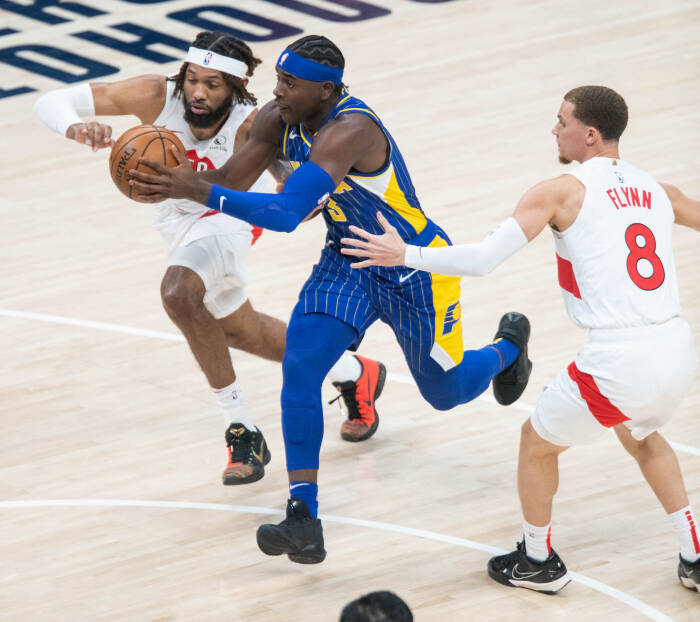 Guard Indiana Pacers Aaron Holiday (3) menggiring bola sementara penyerang Toronto Raptors DeAndre