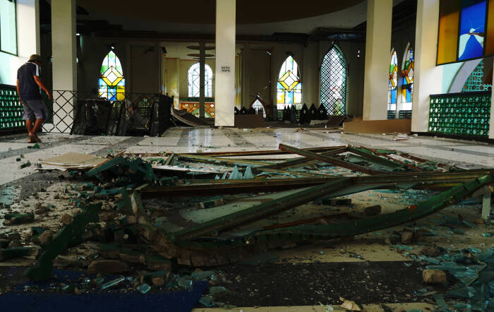 ANTARA FOTO / Akbar Tado Seorang warga melintas di puing bangunan Masjid Agung Suhada yang roboh di Mamuju