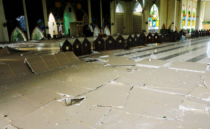 ANTARA FOTO / Akbar Tado Seorang warga melintas di puing bangunan Masjid Agung Suhada yang roboh di Mamuju
