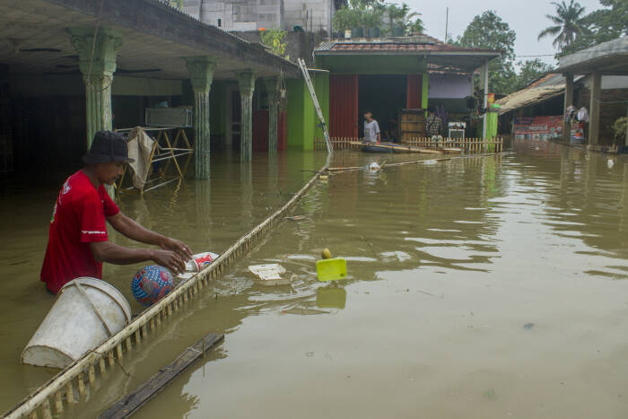 ANTARA FOTO/M Ibnu Chazar Warga membersihkan sampah di sekitar rumahnya saat banjir di Desa Karangligar